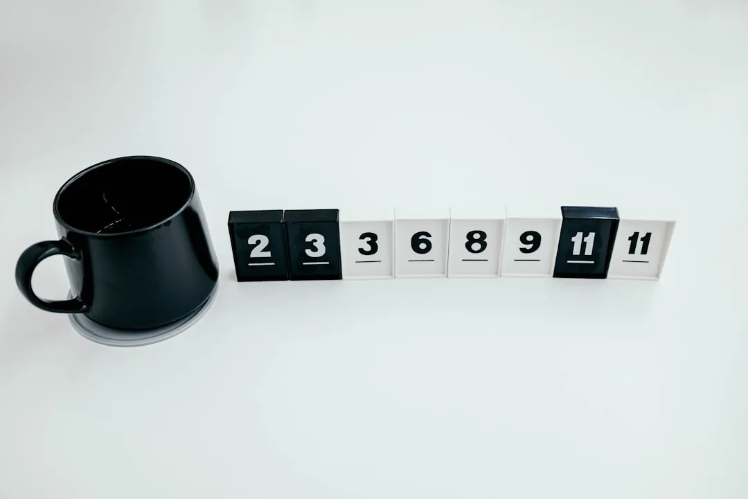 A black coffee mug sitting next to a set of numbers