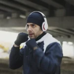Man in headphones boxing under a bridge