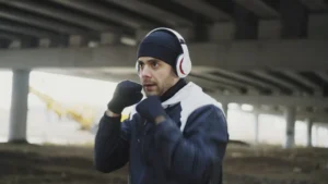 Man in headphones boxing under a bridge