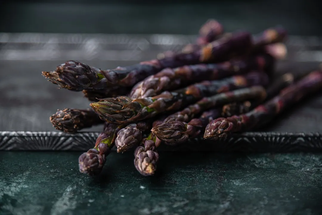 a bunch of asparagus sitting on top of a metal tray