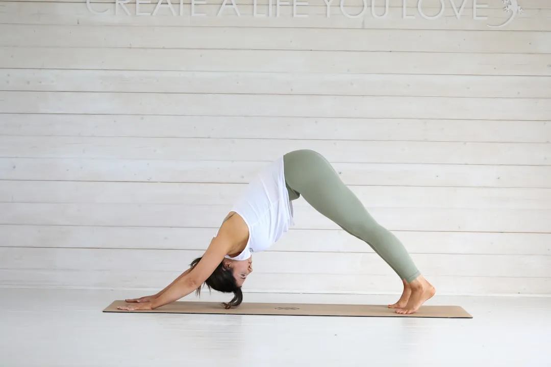 Woman in downward dog yoga pose on mat.