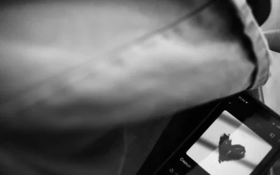 Smartphone screen displays a hand-drawn heart symbol.