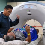 Medical professional assists patient during ct scan procedure.