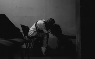 A person sits alone, head in hands.