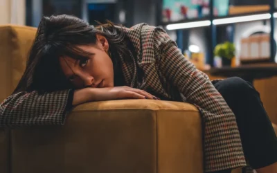 a woman sitting on a couch with her head on her hand