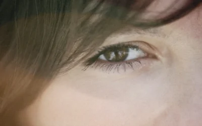 a close up of a person's eye with long hair