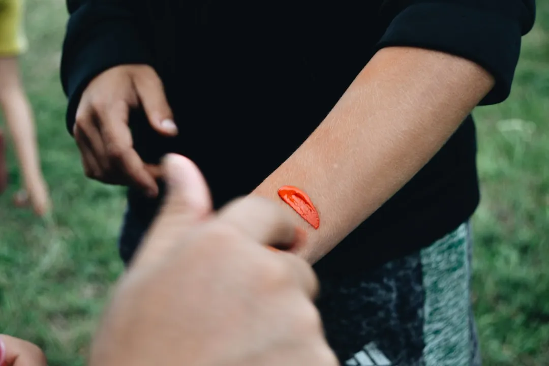 a person with a red sticker on their arm