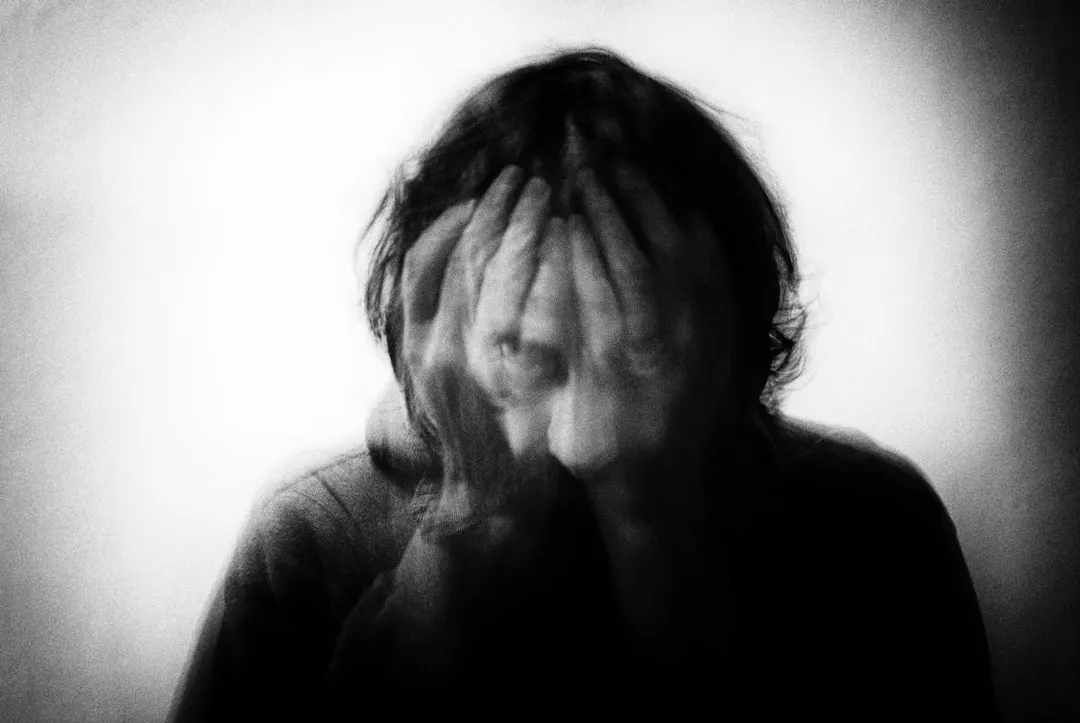 a woman covering her face with her hands