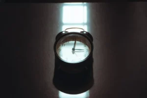 Retro alarm clock on a dark reflective surface.