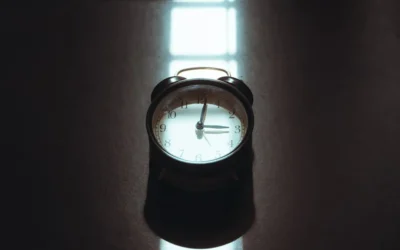 Retro alarm clock on a dark reflective surface.