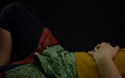 person lying on bed with hands on stomach
