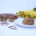 A white plate topped with slices of cake next to bananas
