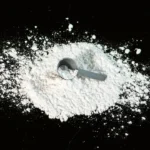 a scoop of powder next to a scoop of sugar
