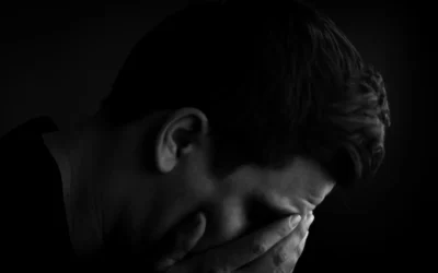 Man with head in hands in dark