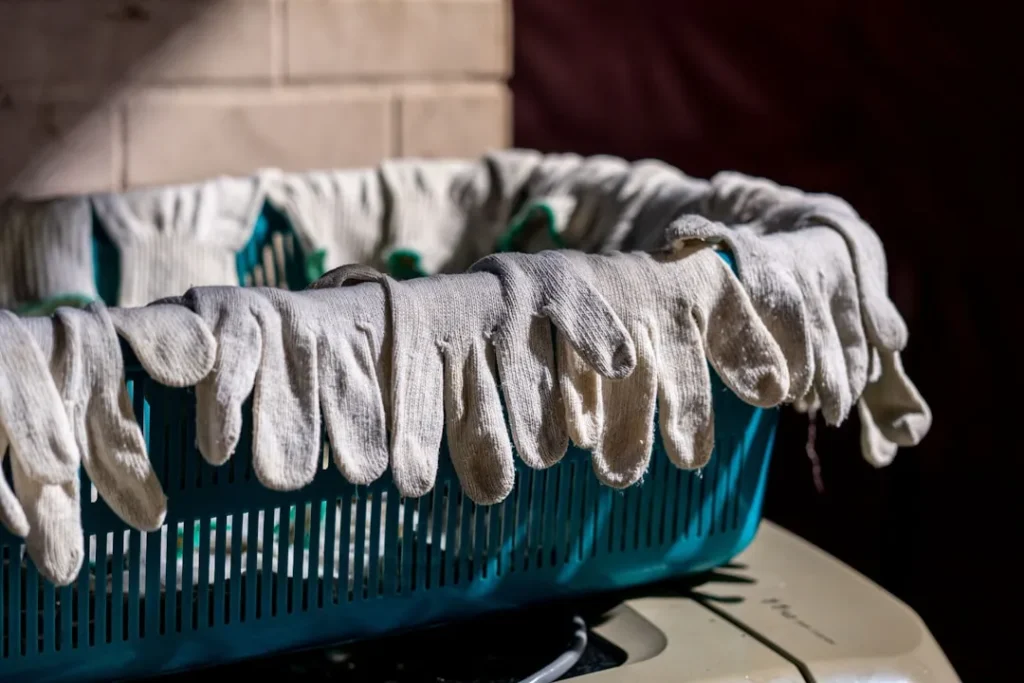 Gloves are hanging over the edge of a basket.