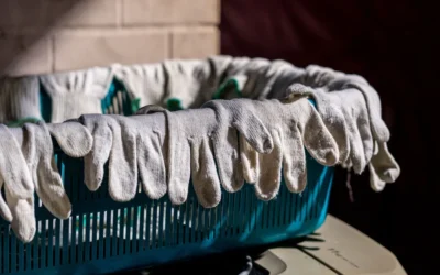 Gloves are hanging over the edge of a basket.
