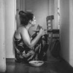 a woman sitting on the floor eating food