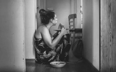 a woman sitting on the floor eating food