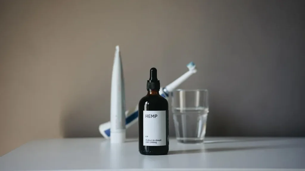 a bottle of liquid sitting on top of a table next to a toothbrush