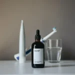 a bottle of liquid sitting on top of a table next to a toothbrush
