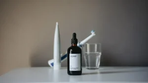 a bottle of liquid sitting on top of a table next to a toothbrush