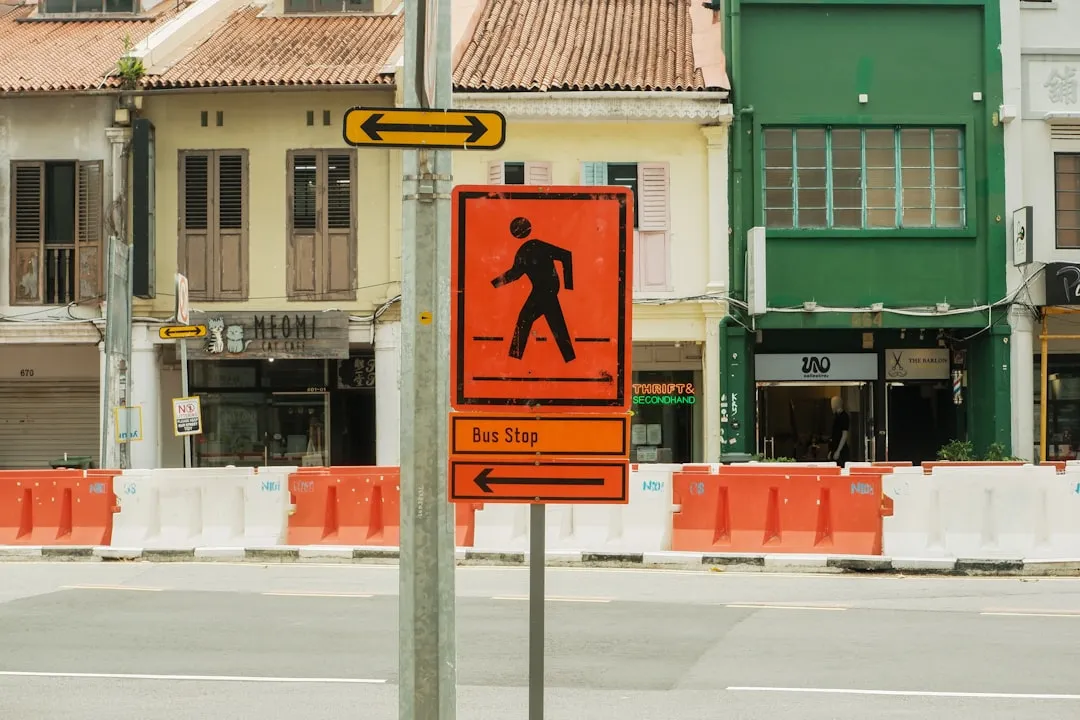 Pedestrian crossing sign with bus stop direction