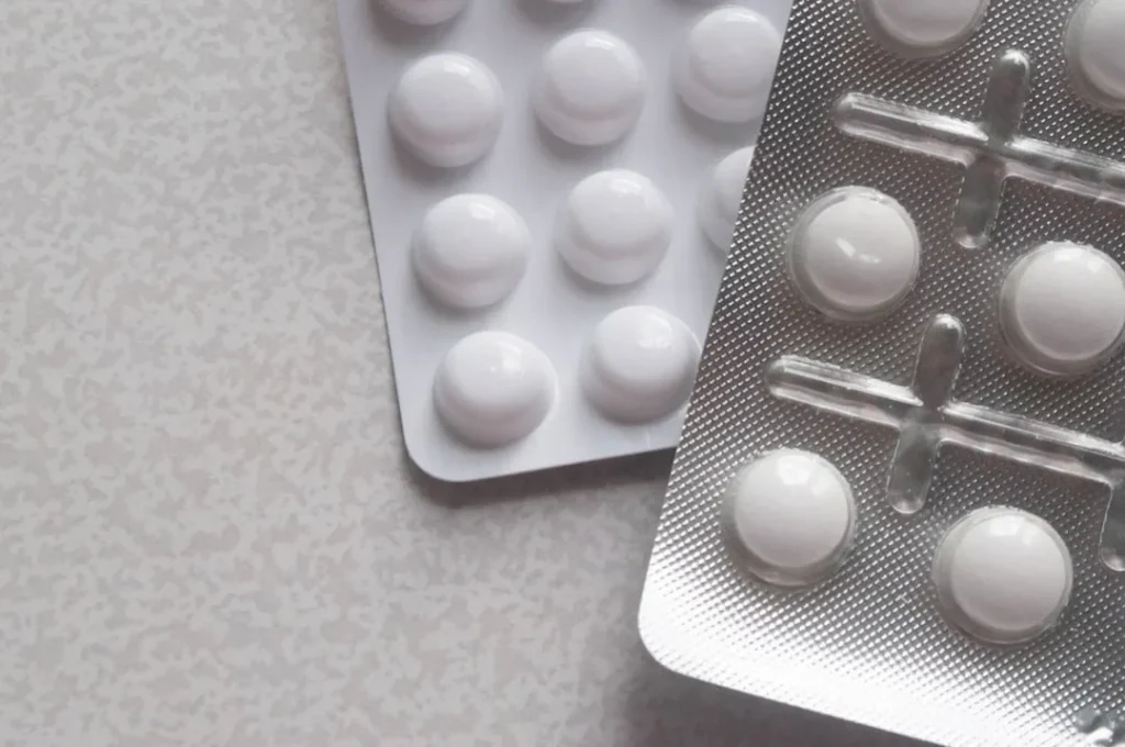 a pack of pills next to a contraption on a table