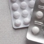 a pack of pills next to a contraption on a table