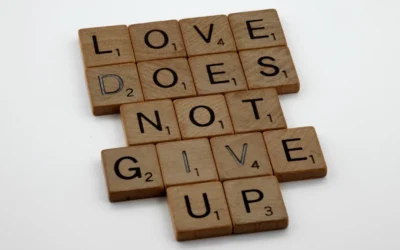 a scrabble tile with the words love does not give up