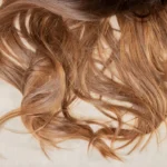 a close up of a woman's hair laying on a bed