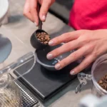 person scooping and measuring coffee beans