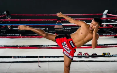 A shirtless man kicking a kick in a boxing ring