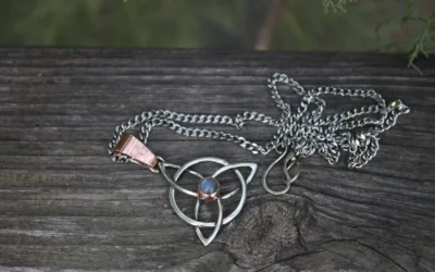 Celtic knot pendant with blue stone on wood